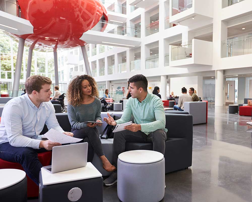 mba-students-talk-in-a-foyer A small group of MBA students chat in an open foyer
